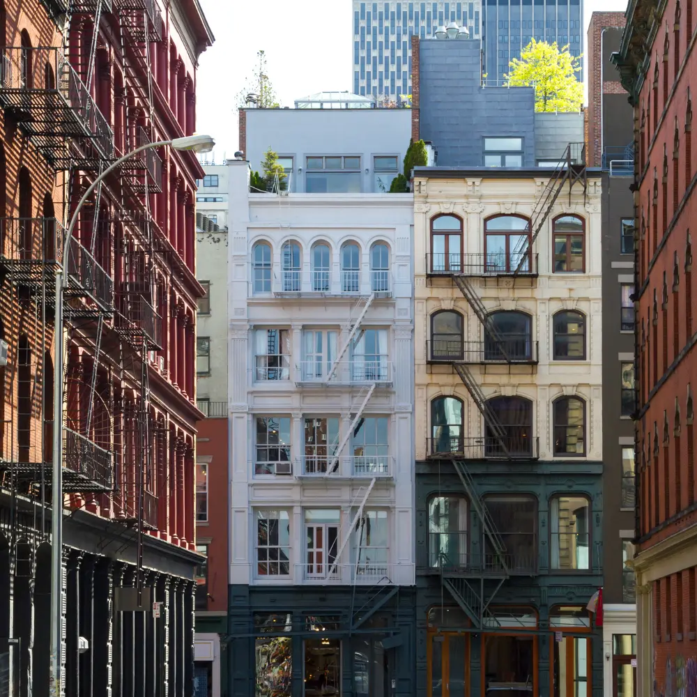 New York residential buildings with fire escapes, representing property sourcing and market research.