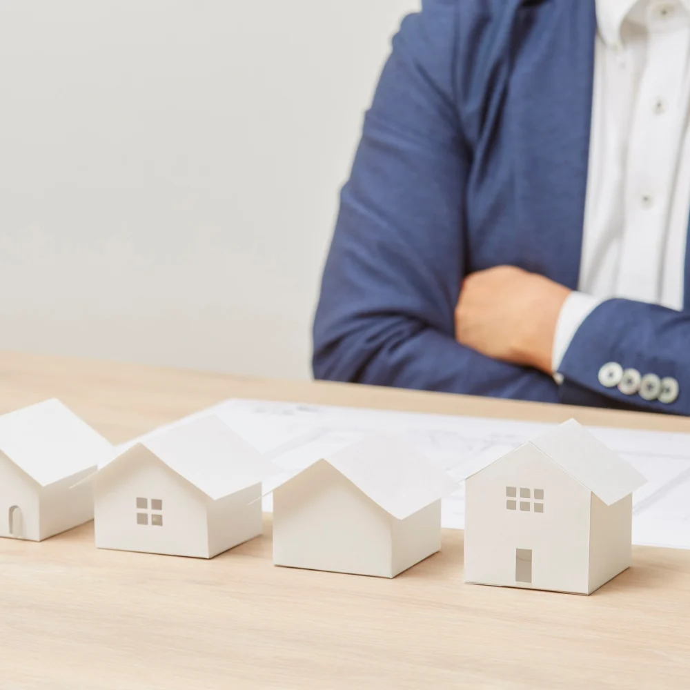 Model of a commercial building placed on due diligence documents for real estate investment